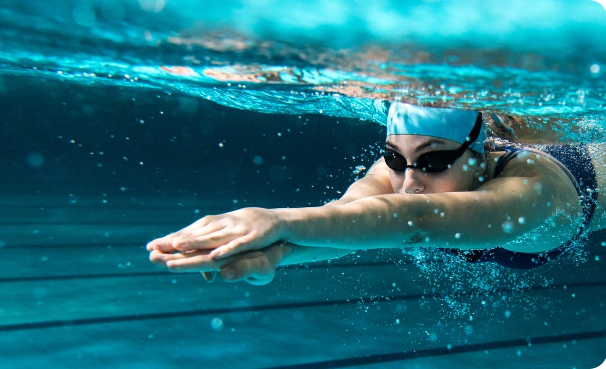 Deportista nadando en piscina como parte de un entrenamiento de alto rendimiento
